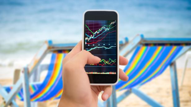 Someone holding a smart phone on a tropical beach