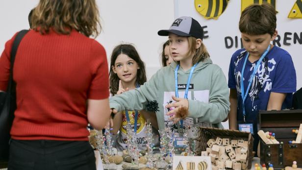 An Marktständen verkaufen die Kinder ihre selbstgebastelten Produkte.  Die Kindervorlesung im Audimax der WU.  Bildquelle: Lydia Naomik