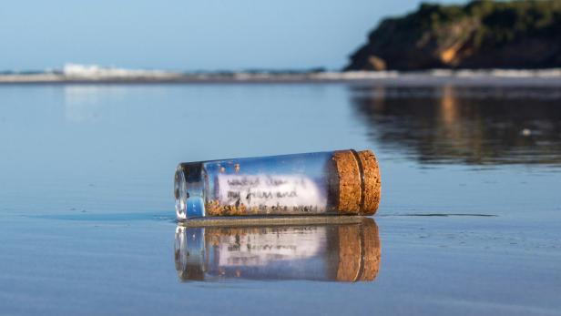 Flaschenpost liegt am Strand